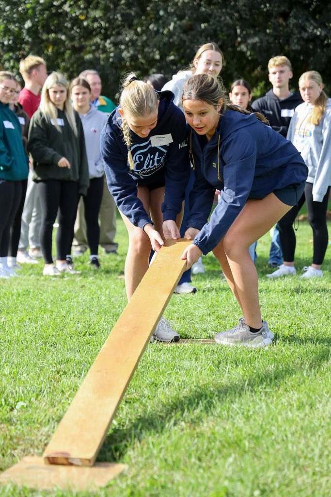 students lifting a board